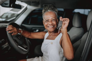 Senior woman buying car show car key